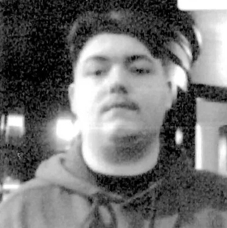 Black and white photo of Tyler Buchanan, alleged ringleader of a hacking group.