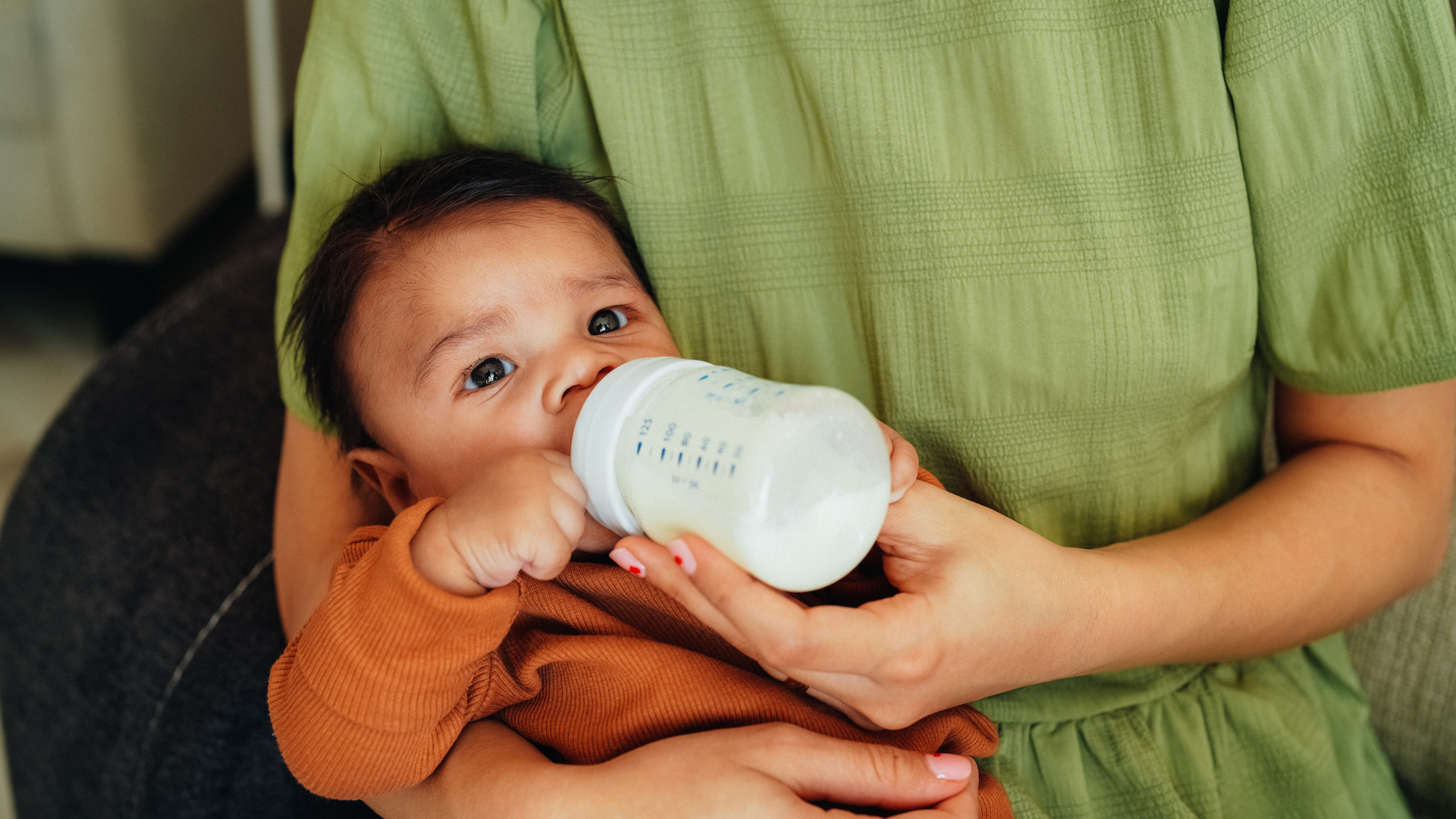 Mother bottle-feeding her newborn baby boy.