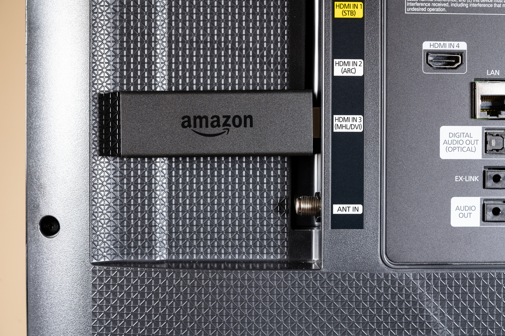 Amazon Fire TV streaming stick plugged into a smart TV's HDMI port.